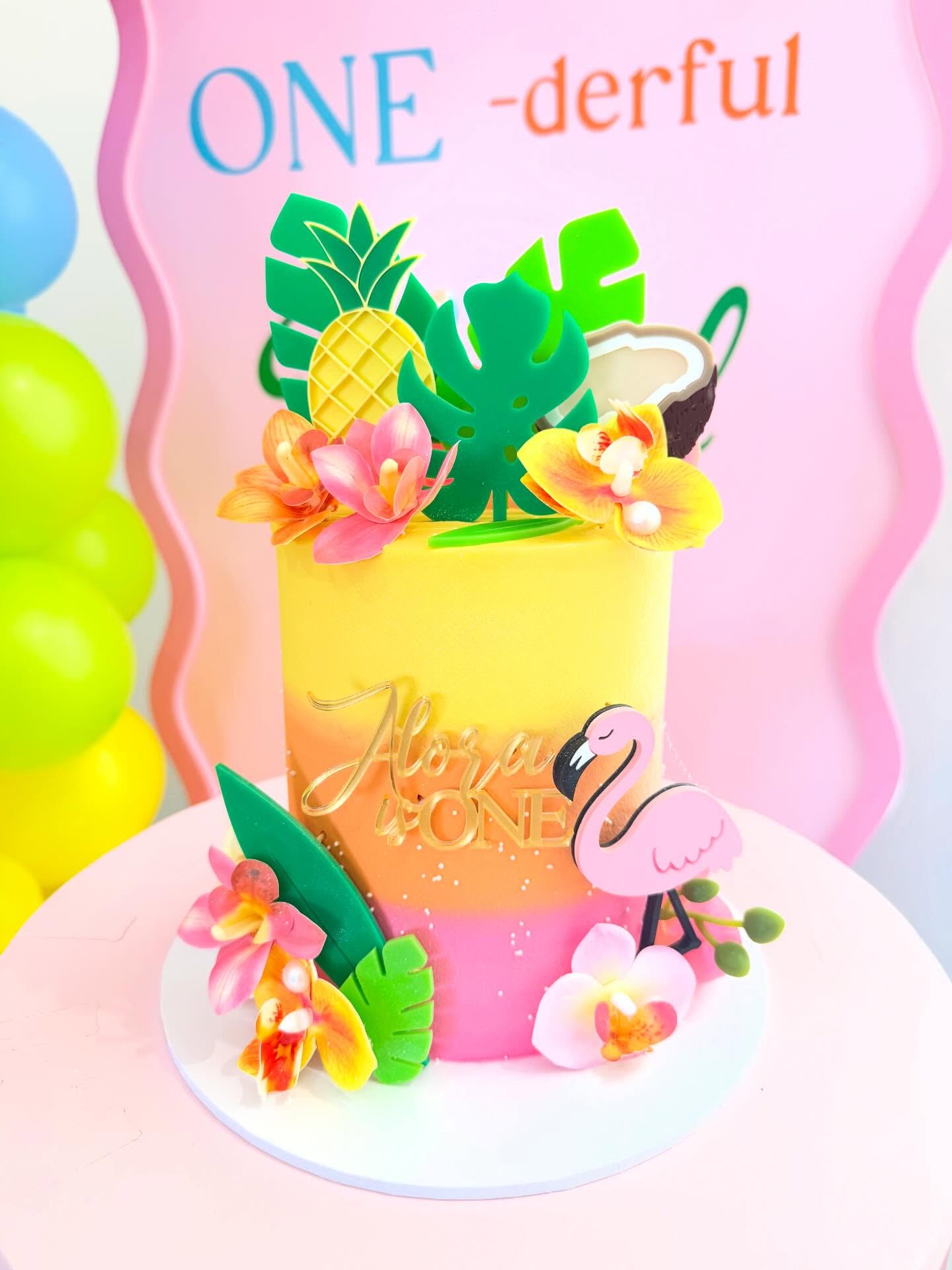 Tropical celebration cake decorated with flowers and a flamingo